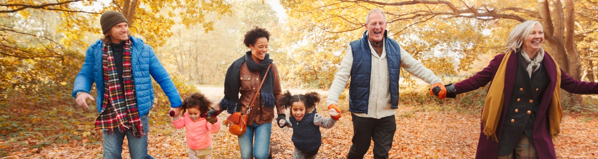 Playful multi-generation family running in autumn park